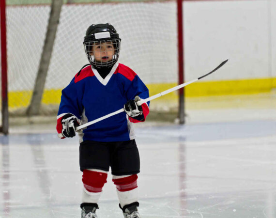 Little Boy Playing Ice Hockey In An Arena