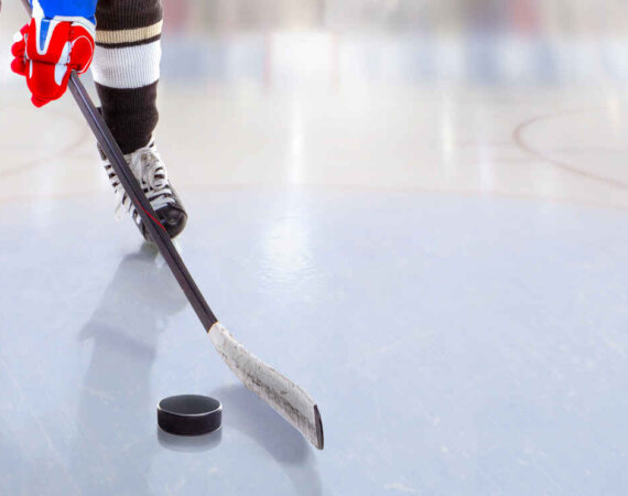 Low Angle View Of Ice Hockey Player With Stick On Ice Rink Contr